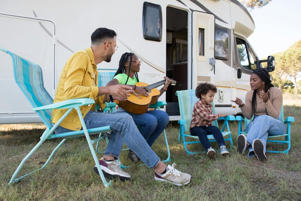 A Family Sitting Beside the Campervan